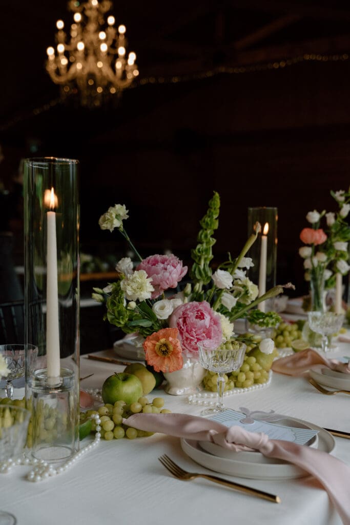 Editorial wedding reception table with fruits, floral arrangements, and elegant place settings at Rivers Edge Resort Manitoba