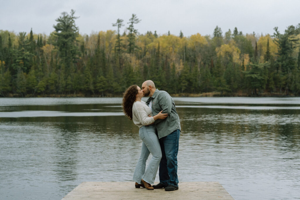 A couple kissing on the dock during an engagement session at Hunt Lake, Manitoba
