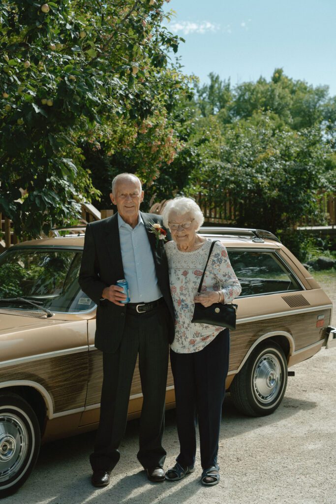 grandparents in front of old school car