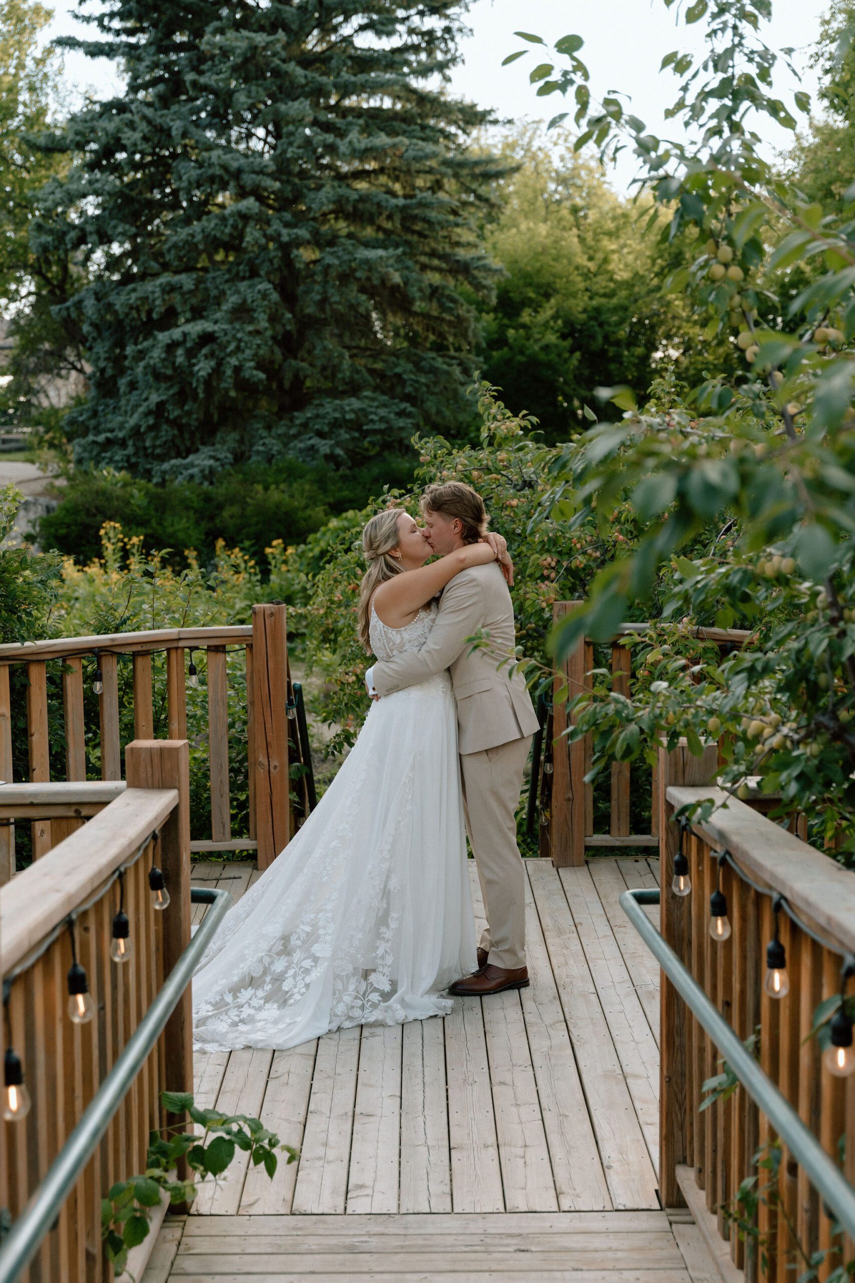 bride and groom kissing on a deck at a wedding at the St. Norbert Arts Center