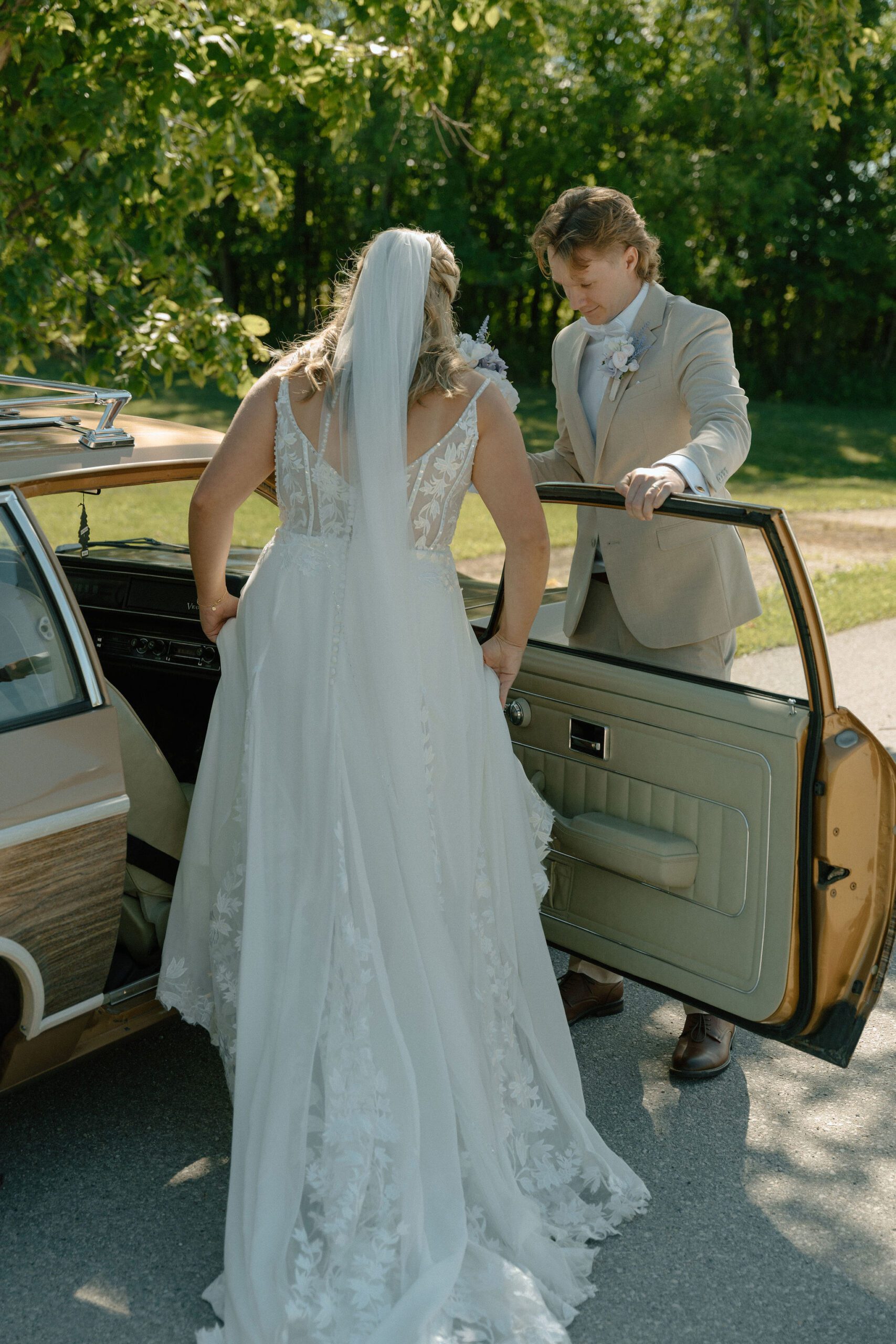 Wedding photo of bride getting in an old school car