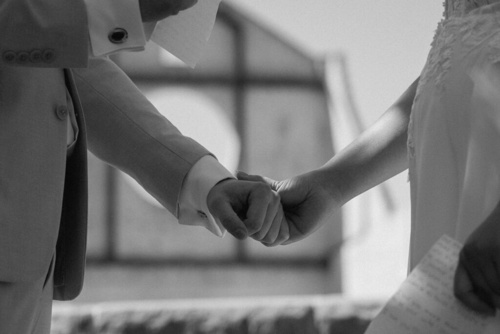 documentary photo of bride and groom holding hands