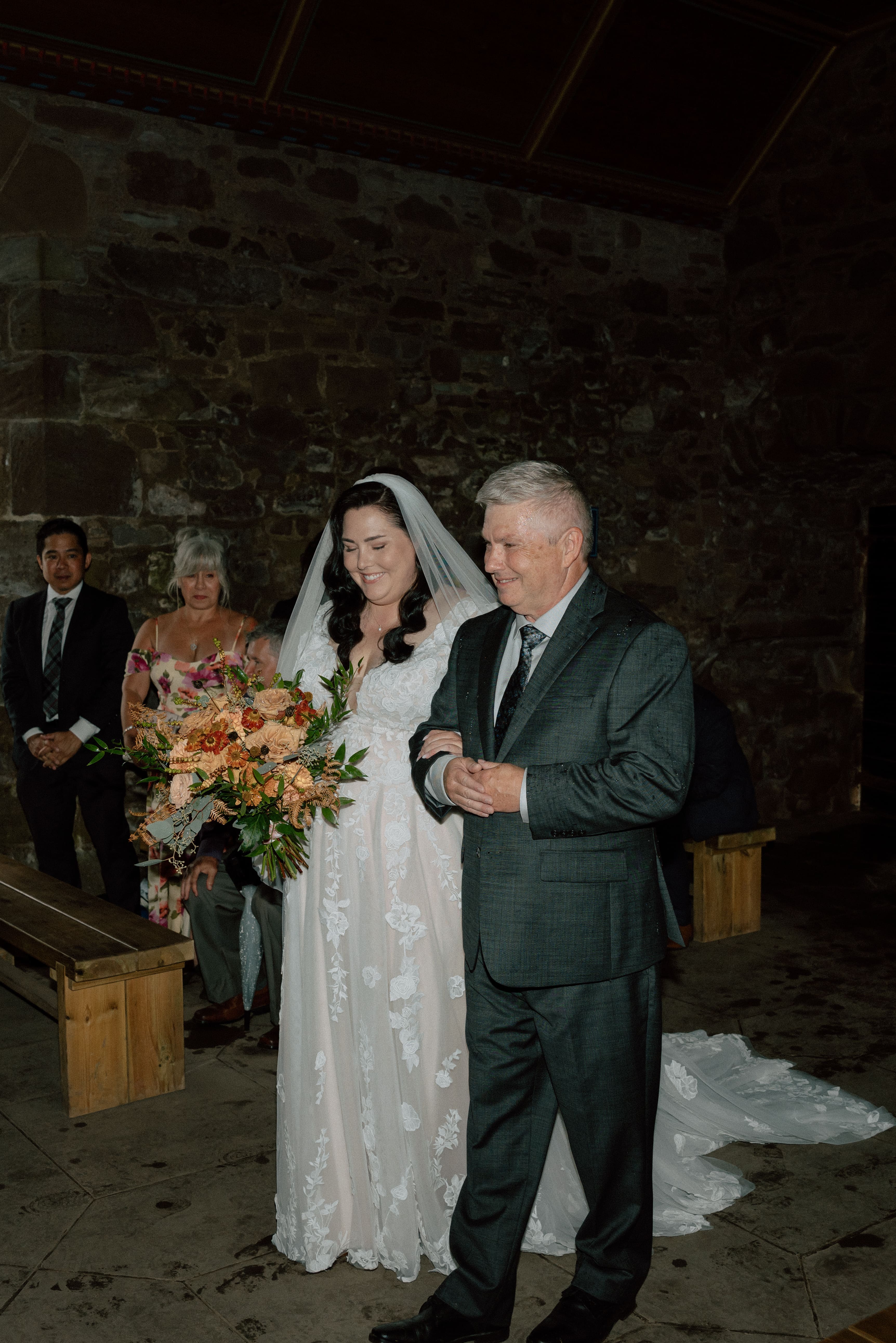emotional moment of father escorting bride down the aisle at Dunnottar Castle wedding ceremony in Stonehaven Scotland