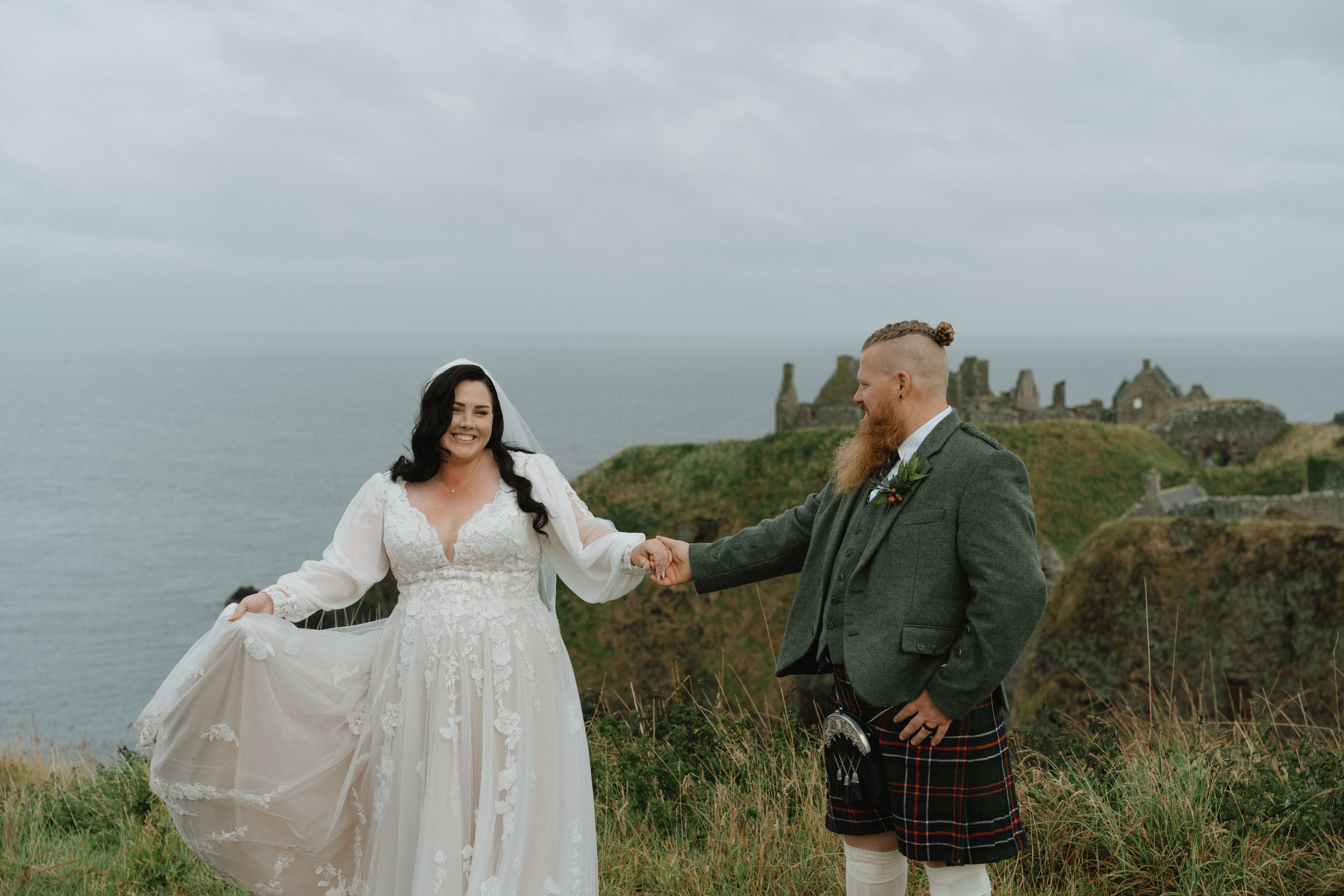 Cinematic documentary wedding photography of a couple dancing on cliffs near Dunnottar Castle, Stonehaven.