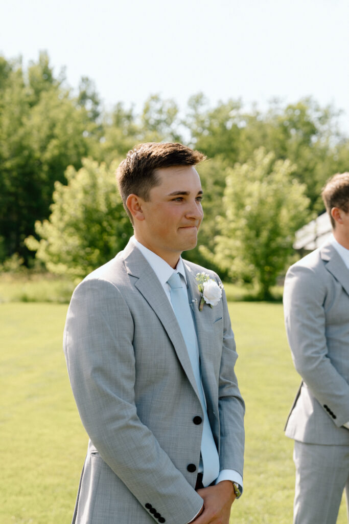 Emotional groom watching his bride walk down the aisle during their White Poplar wedding ceremony