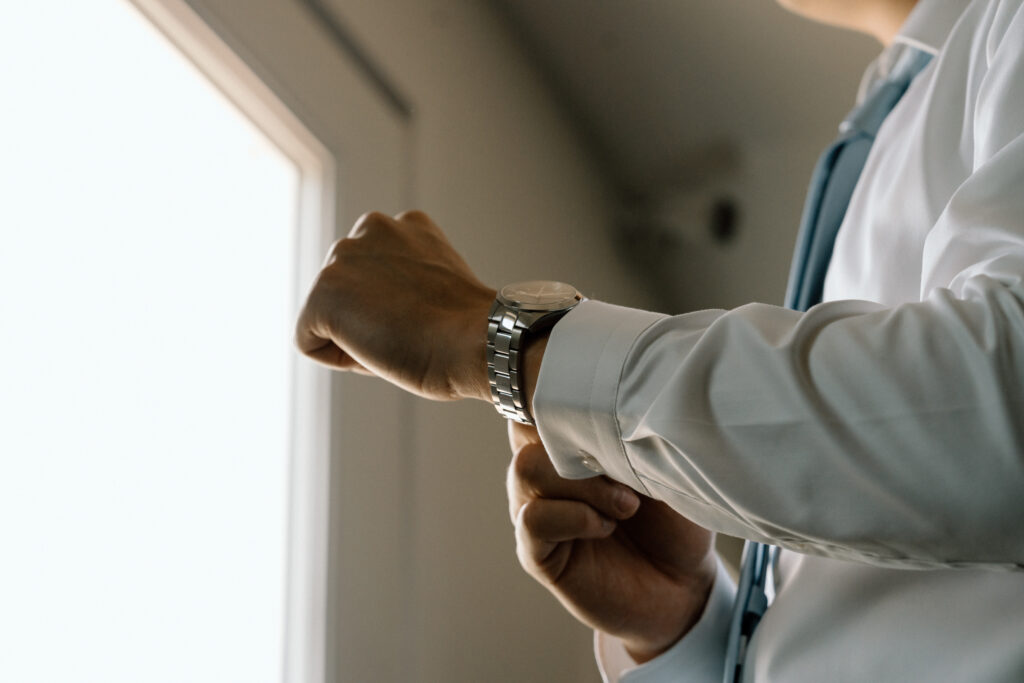 Groom adjusting his cuff and watch during classic wedding getting ready photos in Manitoba