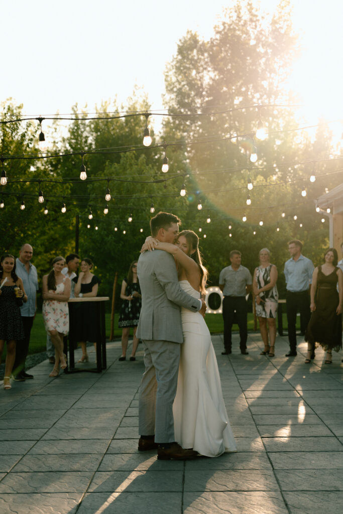 Julianna and Cole embracing during their first dance while wedding guests watch at The White Poplar