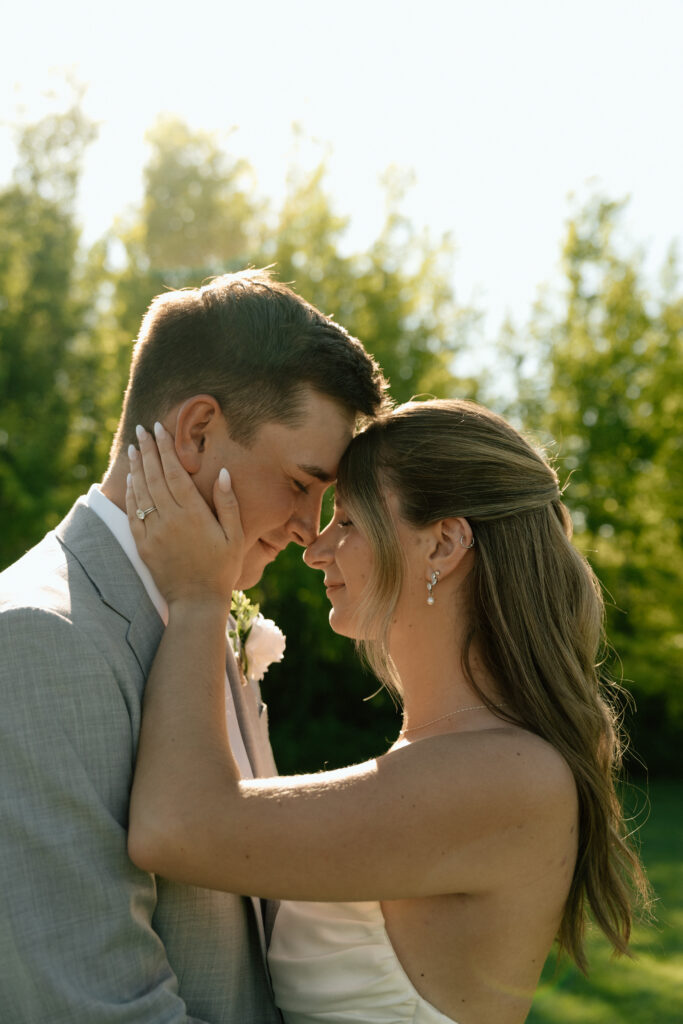 Julianna and Cole sharing a timeless, sunlit wedding portrait at The White Poplar in Manitoba