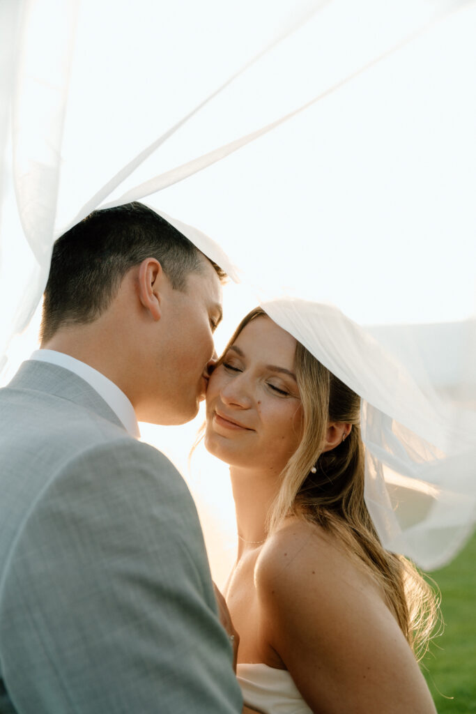 Julianna and Cole sharing an intimate editorial wedding portrait beneath the veil at The White Poplar