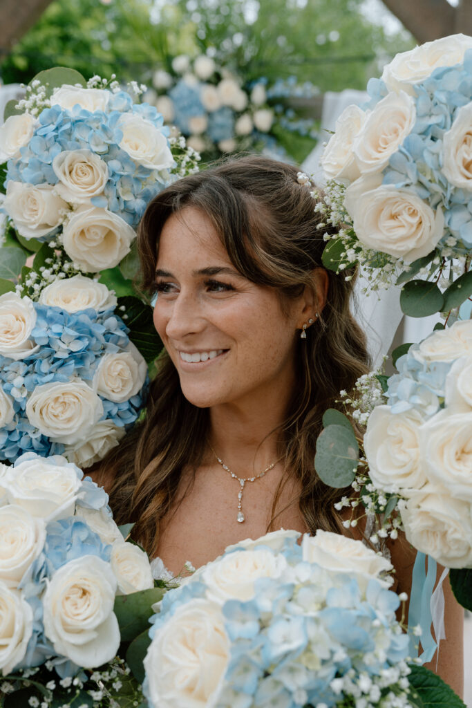 Kayla surrounded by wedding bouquets during her bridal portraits at Hawthorne Estates in Manitoba