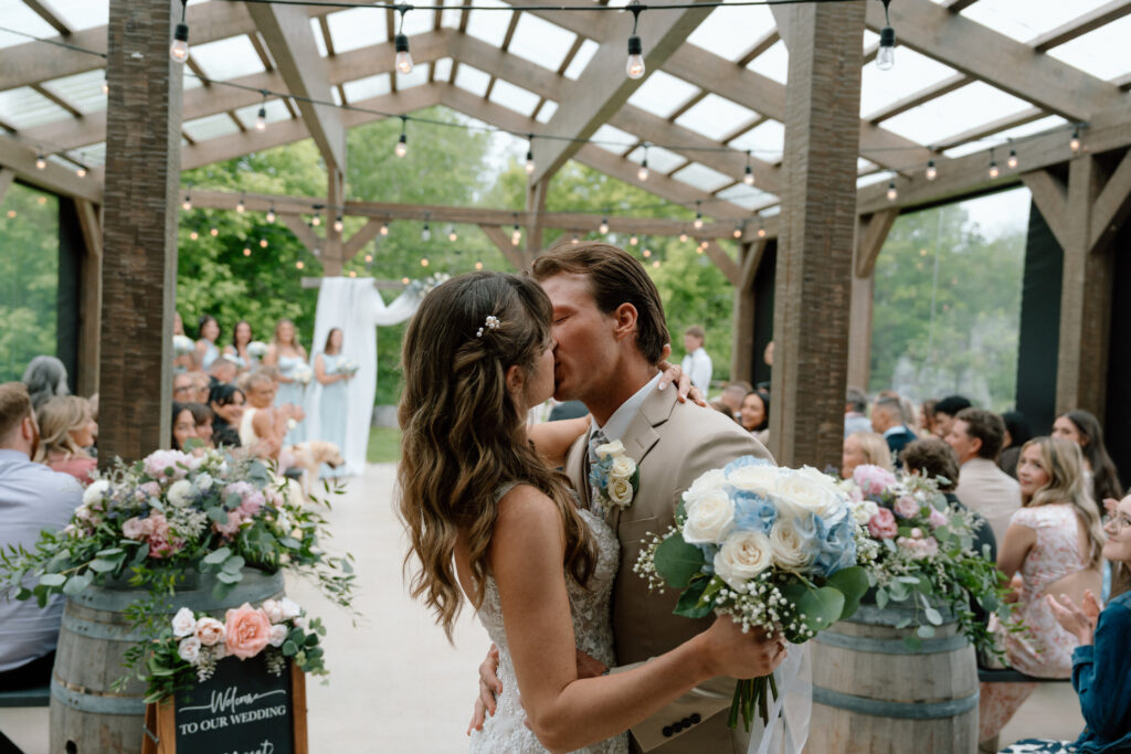Kayla and Myles sharing their first kiss as newlyweds during their Hawthorne Estates wedding ceremony