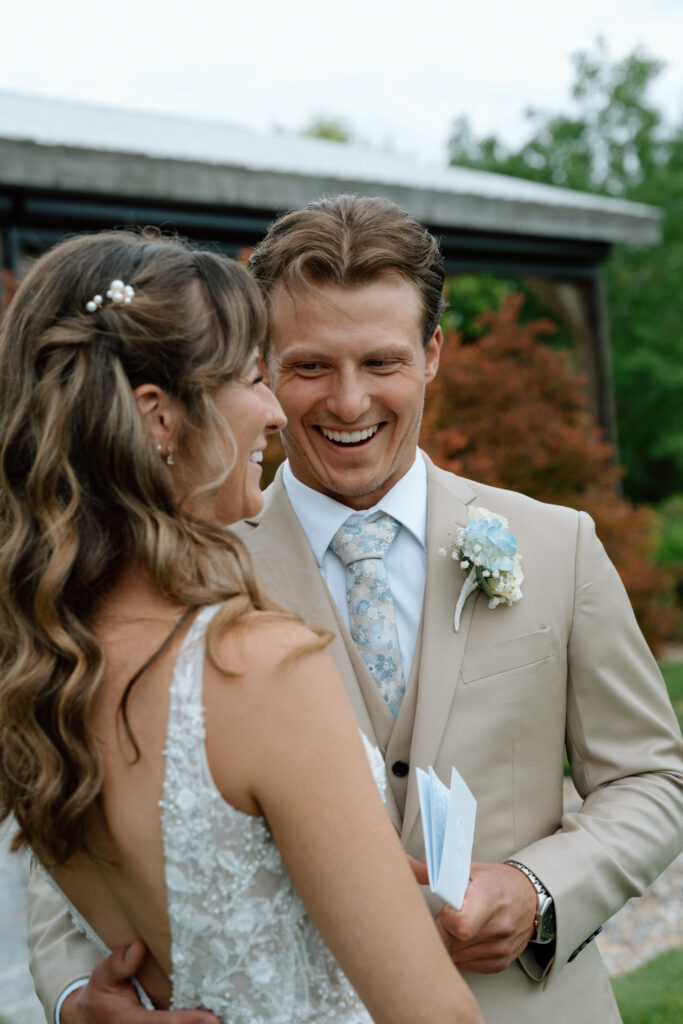 Bride and groom laughing together after their first look at Hawthorne Estates in Manitoba