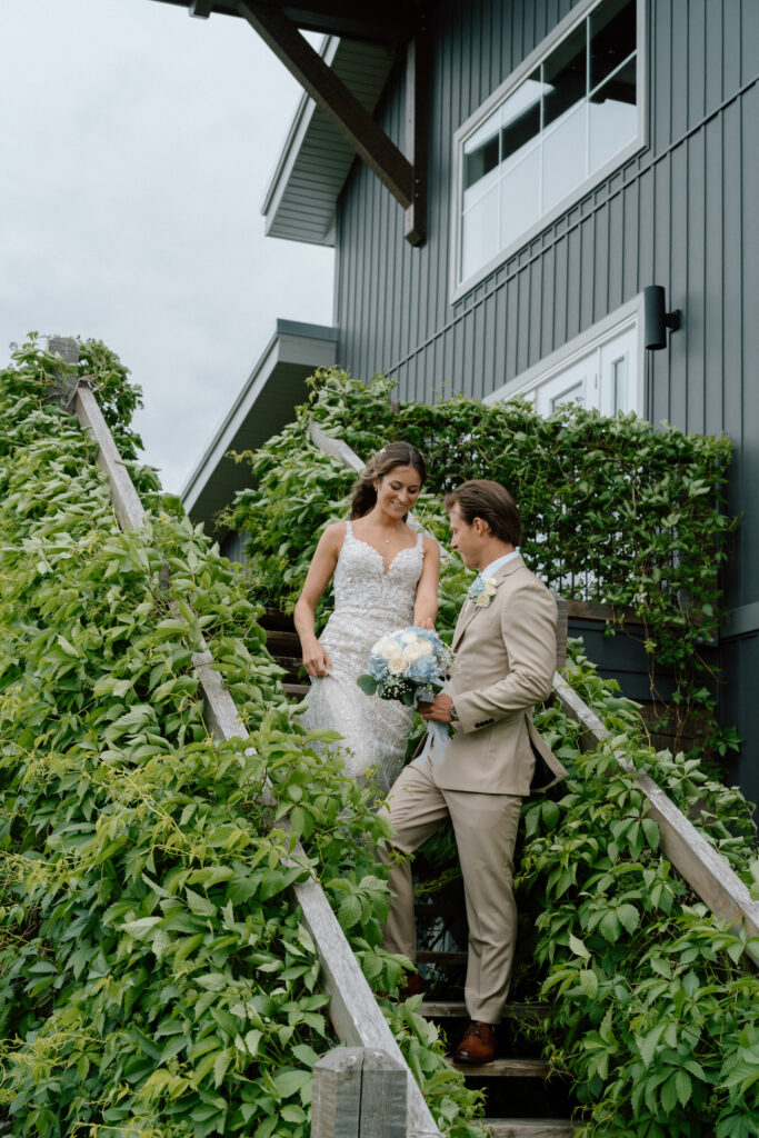 Myles helping Kayla down the stairs during their wedding portraits at Hawthorne Estates