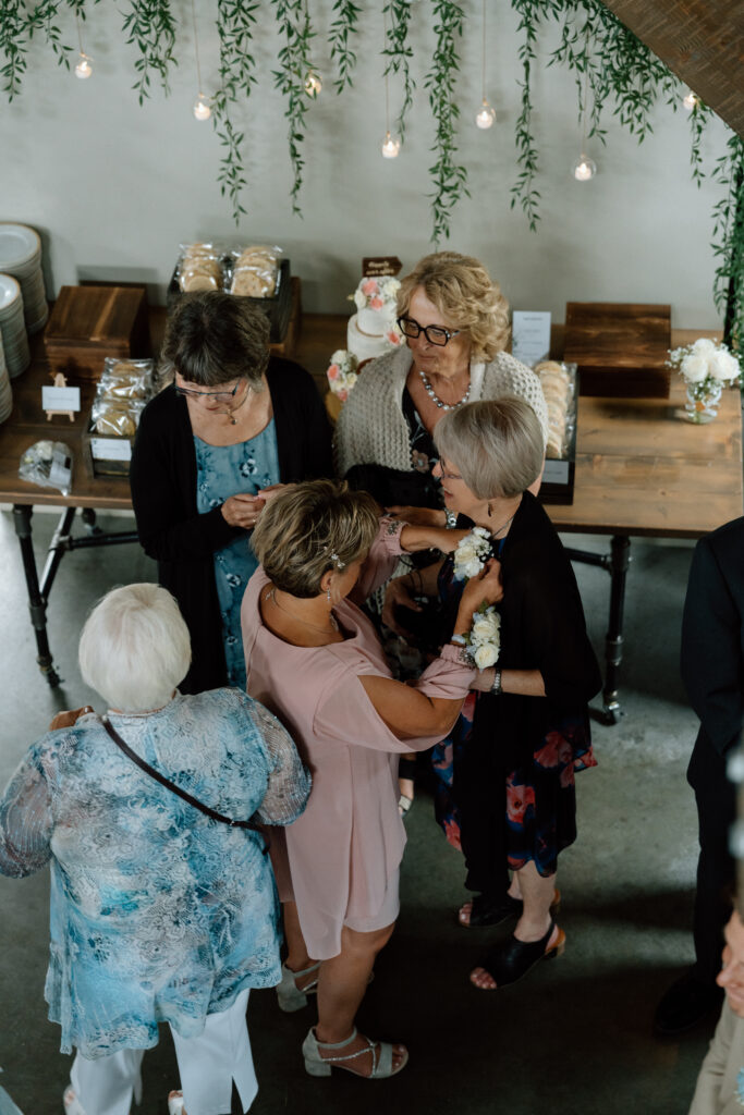 Group of women helping prepare a wedding corsage at Kayla and Myles’ Hawthorne Estates wedding