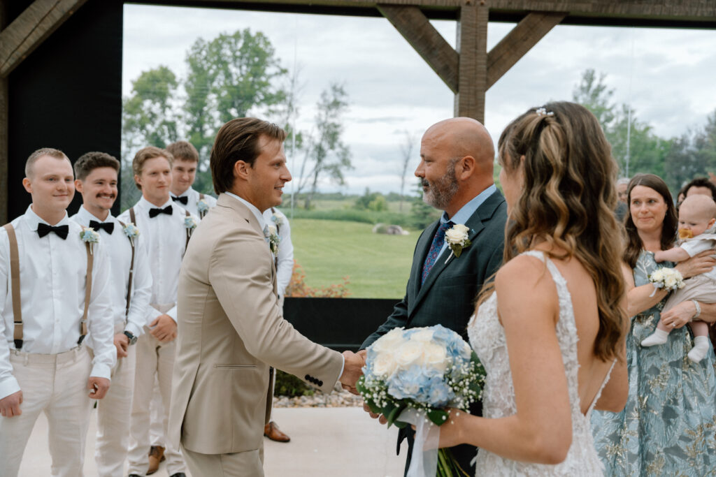 Myles shaking hands with Kayla’s father at the wedding ceremony at Hawthorne Estates