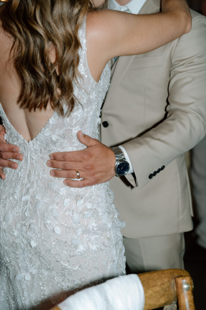 Close-up of Myles’ hand on Kayla’s waist during their wedding reception at Hawthorne Estates