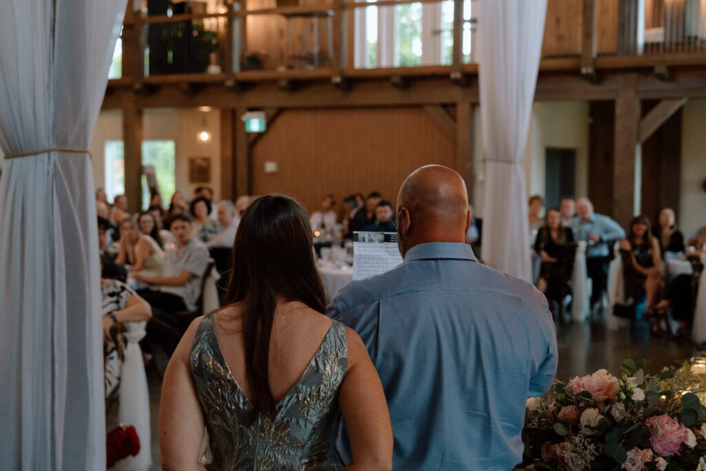 Two wedding speakers addressing guests during Kayla and Myles’ reception at Hawthorne Estates in Manitoba